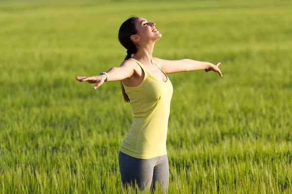 Schöne junge Frau genießt den Frühling stehen in einem Getreide f — Stockfoto