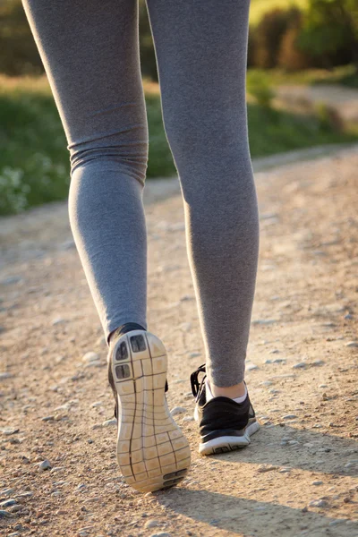 Detalhe das pernas da mulher andando no campo — Fotografia de Stock