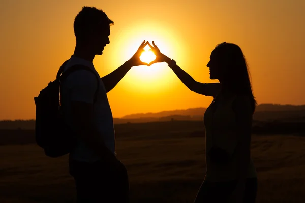 Silhouette of young couple in field. — Stock Photo, Image