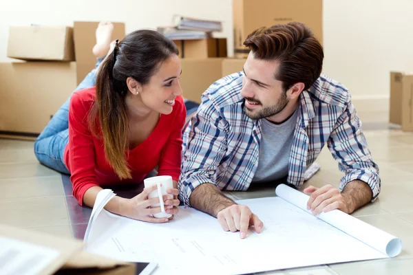 Pareja joven mirando los planos de su nuevo hogar —  Fotos de Stock