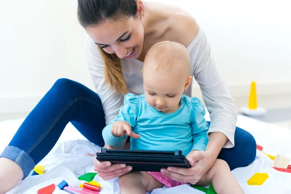 Mãe e bebê usando tablet digital em casa — Fotografia de Stock