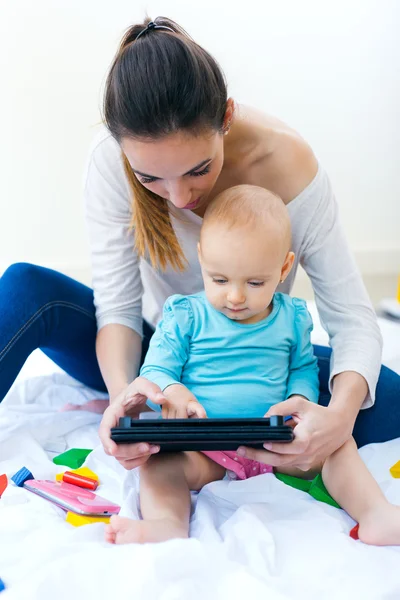 Mãe e bebê usando tablet digital em casa — Fotografia de Stock