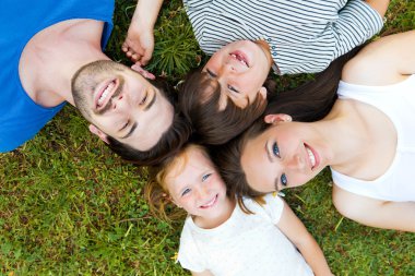heureux jeune famille couché sur l'herbe 