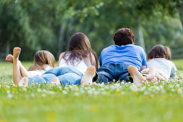 잔디에 누워 행복 한 젊은 가족 — 스톡 사진