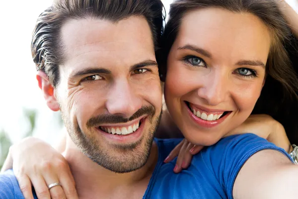 Happy young couple taking selfies with her smartphone in the par — Stock Photo, Image