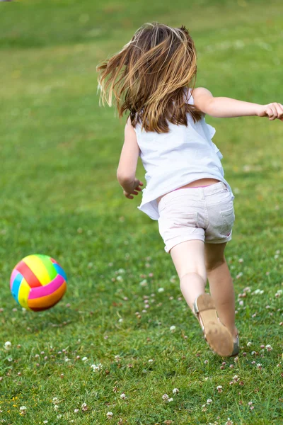 Glückliches kleines Mädchen beim Ballspielen im Park. — Stockfoto