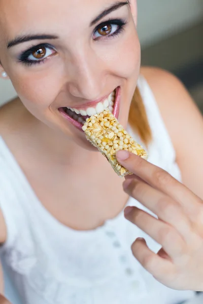 Kvinna äta müsli bar mellanmål. — Stockfoto