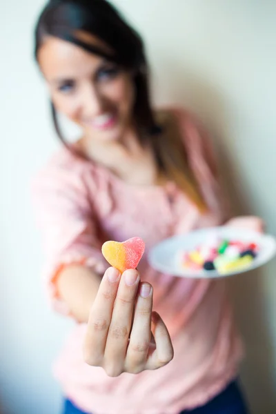 Söt ung kvinna äta gelé godis med en färsk leende — Stockfoto