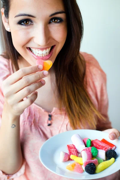 Leuke jonge vrouw eten gelei snoepjes met een frisse glimlach — Stockfoto