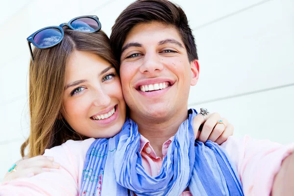 Retrato ao ar livre de jovens casais felizes tirando fotos com um smar — Fotografia de Stock