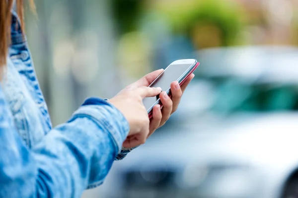 Mobile phone in a woman's hand. Outdoor image. — Stock Photo, Image