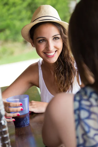 Menina bonita bebendo no bar da piscina com amigo . — Fotografia de Stock
