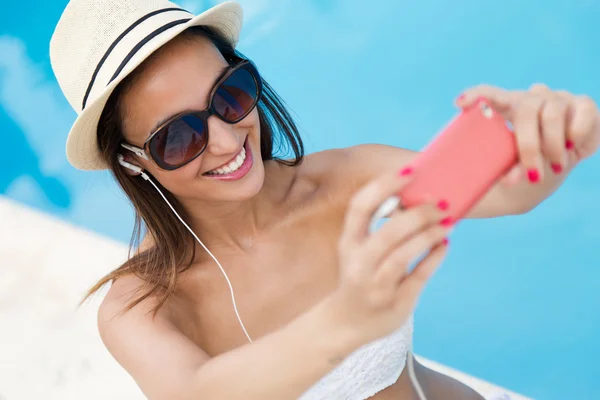 Belle fille prenant un selfie à la piscine . — Photo