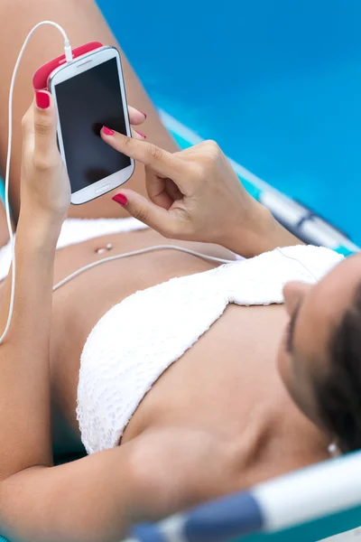 Menina bonita ouvir música na piscina . — Fotografia de Stock