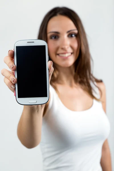 Hermosa mujer mostrando el teléfono móvil. Aislado sobre blanco . — Foto de Stock