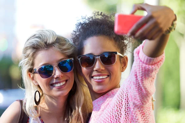 Deux étudiantes de l'université prennent un selfie dans la rue . — Photo