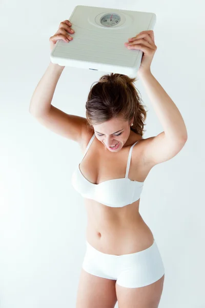 Frustrated woman with scale. Isolated on white. — Stock Photo, Image