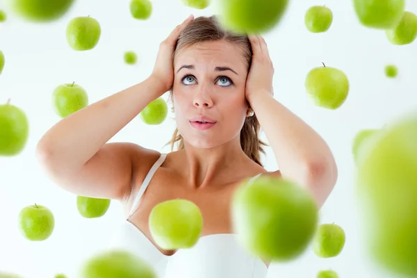 Young girl overwhelmed by diet, surrounded by apples. — Stock Photo, Image