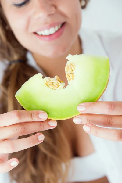 Jeune femme en sous-vêtements mangeant du melon. Isolé sur blanc . — Photo