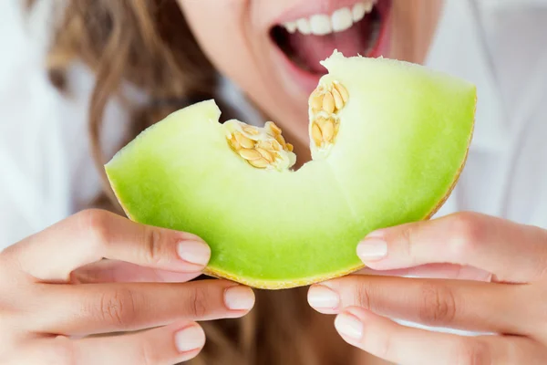 Jeune femme en sous-vêtements mangeant du melon. Isolé sur blanc . — Photo