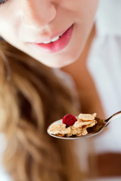 Jonge vrouw in ondergoed eten granen. geïsoleerd op wit. — Stockfoto