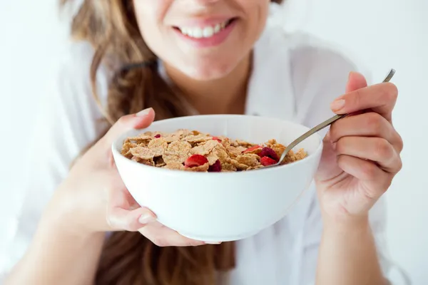 Mujer joven en ropa interior comiendo cereales. Aislado sobre blanco . —  Fotos de Stock