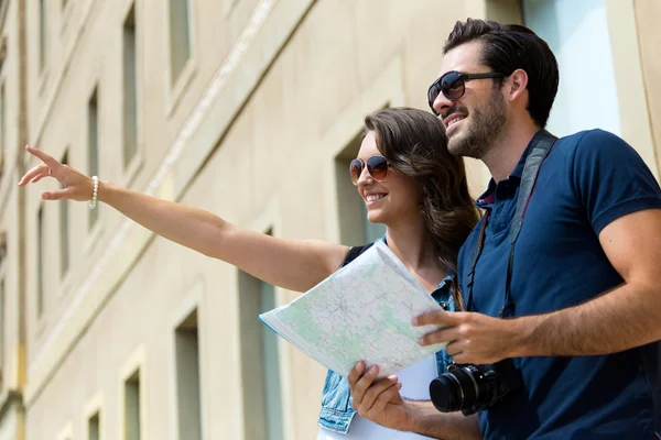 Onların harita ve onlar istemek işaret eden genç bir turist Çift kullanın — Stok fotoğraf