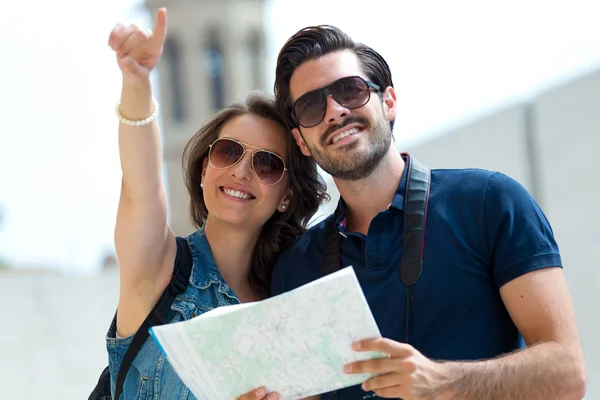 Les jeunes couples de touristes utilisent leur carte et pointent où ils veulent — Photo