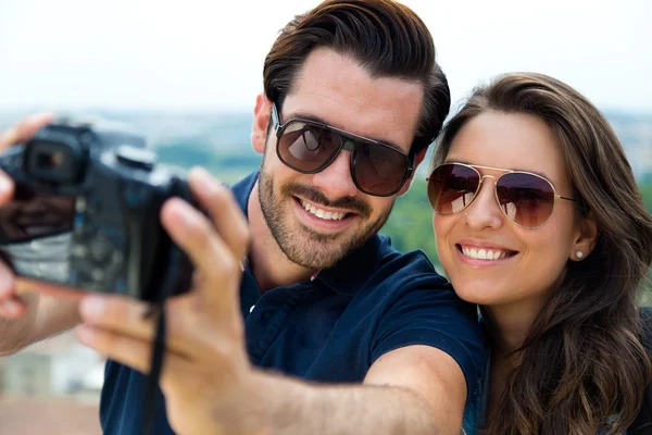 Jeune couple touristique prenant des photos d'eux-mêmes . — Photo