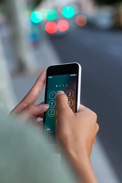 Telefone celular na mão de uma mulher na cidade à noite . — Fotografia de Stock