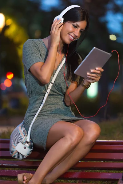 Hermosa chica escuchando música en la ciudad por la noche . — Foto de Stock