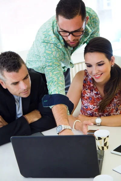 Casual executives working together at a meeting with laptop. — Stock Photo, Image