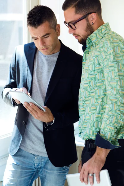 Deux hommes d'affaires utilisant une tablette numérique au bureau . — Photo