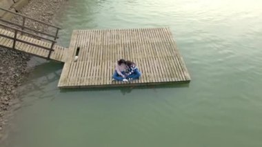 İki kızın gölün ortasında köprüde konuşurken akıllı telefonlarını kullandıkları bir video.