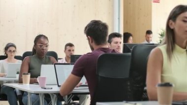 Bir iş yerinde bilgisayarlarla çalışan çok ırklı iş adamlarının videosu..