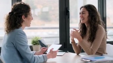 Güzel bir emlakçının, ev planlarını elektronik tablette gösterirken güzel bir kadınla emlak satın alma hakkında konuşurken çekilmiş videosu.