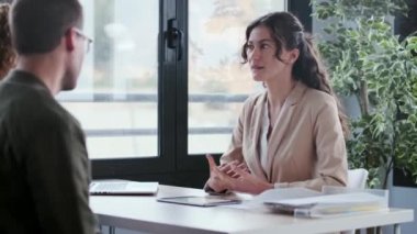 Güzel bir emlakçının, ev planlarını elektronik tablette gösterirken çiftle bir emlak şirketinden ev alma konusunu konuşurken çekilmiş videosu.