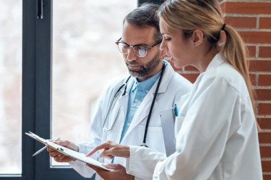 Tıbbi konsültasyonda kendine güvenen kadın ve erkek doktorların tıbbi bilgiler hakkında konuştuğu bir iğne..