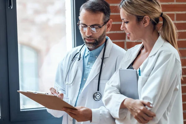 Tıbbi konsültasyonda kendine güvenen kadın ve erkek doktorların tıbbi bilgiler hakkında konuştuğu bir iğne..