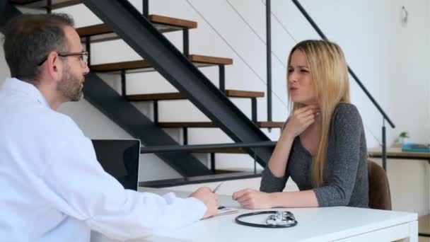 美しいです患者のビデオ彼女の成熟した男性医師に説明彼女の痛みについての相談 — ストック動画