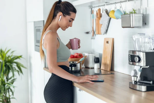 Evde Mutfakta Kahve Içerken Akıllı Telefonuyla Müzik Dinleyen Sportif Bir — Stok fotoğraf