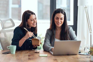 Tasarım projesinde çalışan iki güzel tasarımcının biri ofiste şehriye yerken çekimleri..