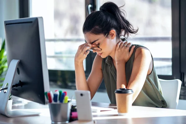 オフィスでコンピューターと仕事をしながら不快に見える頭痛の種ビジネス女性のショット — ストック写真