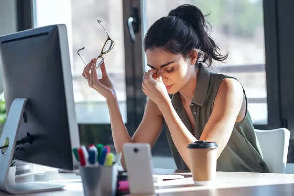 オフィスでコンピューターと仕事をしながら不快に見える頭痛の種ビジネス女性のショット — ストック写真