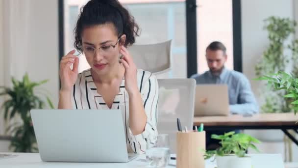 オフィスでコンピュータを操作しながら不快な顔をして頭痛の種ビジネス女性のビデオ — ストック動画