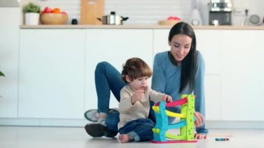 Evdeki oturma odasında oğluyla yerde oynayan güzel bir annenin videosu..