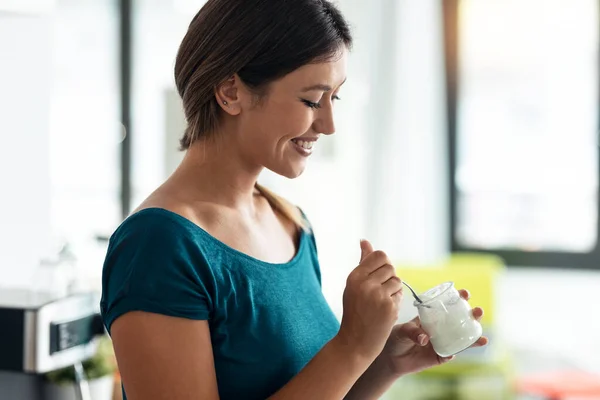 Evdeki Mutfakta Durup Gülerken Yoğurt Yiyen Güzel Mutlu Bir Kadının — Stok fotoğraf