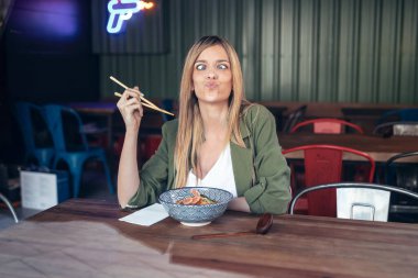 Asya restoranında komik surat yaparken güzel bir kadının çubukla ramen yemesi..