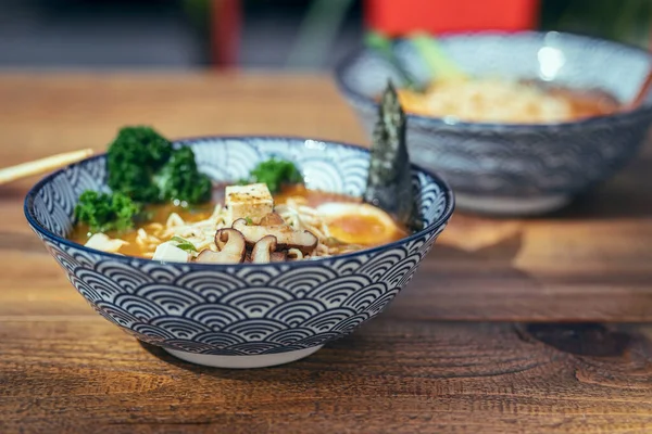 Asya erişte çorbası, sebzeli ramen ve Asya restoranındaki bir masada yumurta..