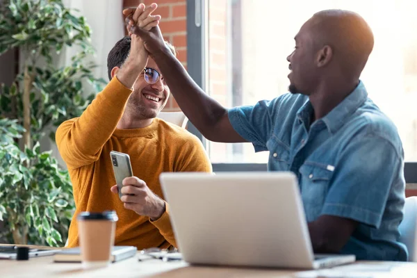 Tiro Dois Designers Gráficos Trabalhando Com Laptop Enquanto Celebra Algo — Fotografia de Stock